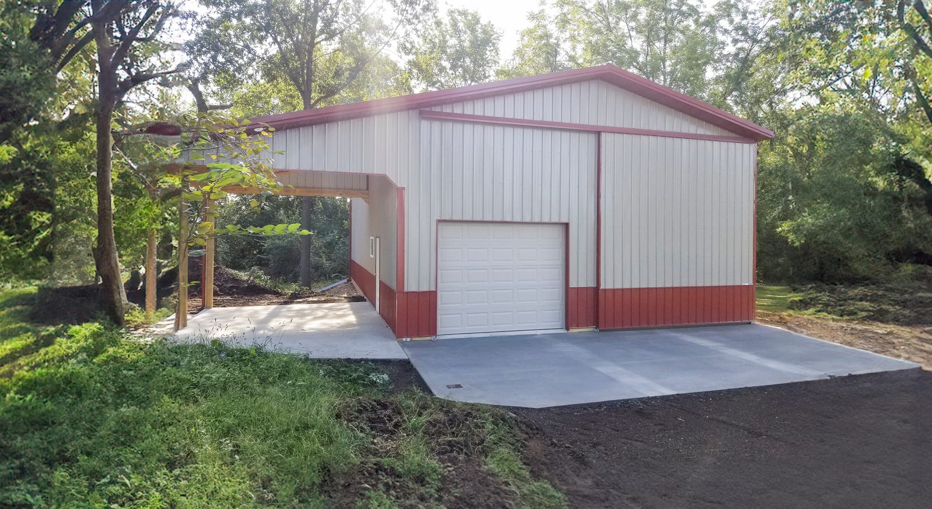 The image shows a post-frame construction building by Built-Mor Buildings. It features a metal exterior with alternating red and white vertical panels. The structure has a large roll-up garage door, indicating its use for storage or as a workshop. The roo
